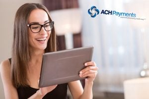 So useful. Gorgeous young woman with glasses smiling and holding a tablet while standing in a room